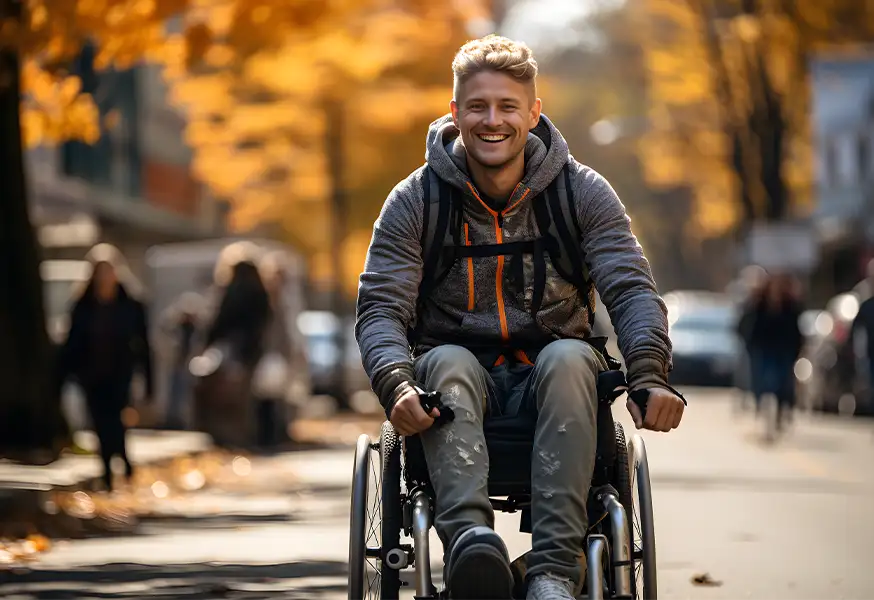 Szczęśliwy młody mężczyzna na wózku inwalidzkim jesienią